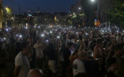Protesters light up mobile phones as they demonstrate in front of the prosecutors offices calling for the release of their peers who were detained in protests the previous night