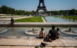 Tourists cool off in the Trocadero Fountain in front of the Eiffel Tower