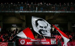 Monza fans wave a flag emblazoned with the image of flamboyant former owner Silvio Berlusconi