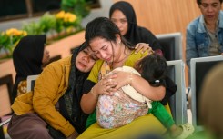 Family members wait at Ketapang Port in East Java for updates on the search for missing people after a ferry sank on its way to the popular Indonesian resort island of Bali