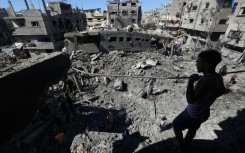 A Palestinian inspects the damage after an Israeli strike on Al-Bureij refugee camp in the central Gaza Strip