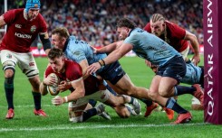 British and Irish Lions' Huw Jones (bottom) scores a try against the NSW Waratahs