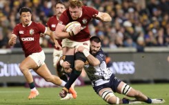 British and Irish Lions' Ollie Chessum (C) is tackled by ACT Brumbies' Luke Reimer
