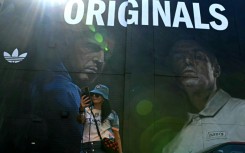 An Oasis fan takes a selfie in front of mural of the band's Gallagher brothers in their Manchester hometown