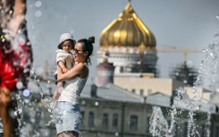 People cool off in front of Moscow's Christ the Saviour Cathedral, as the Russian capital sweltered under record heat