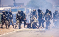 US Customs and Border Protection officers make an arrest after pulling a person out of their vehicle outside an immigation raid at Glass House Farms in Camarillo, California