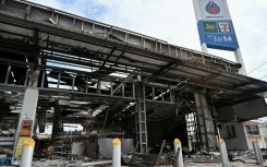 Damage from a fire caused by Cambodian artillery at a 7-11 convenience store is seen at a gas station in the Thai border province of Sisaket
