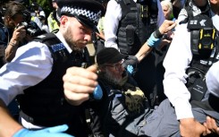British police moving in on a small group of protesters displaying signs supporting Palestine Action