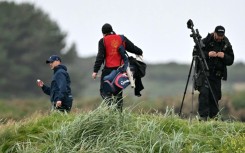 Golfers look for a ball in the rough as snipers and security personnel inspect the area before Trump played another round at his Trump Turnberry Golf Courses, ahead of a key meeting with the EU chief