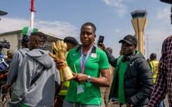 Nigerian goal keeper Chiamaka Nnadozie holds a trophy from the Women's Africa Cup of Nations (WAFCON) as she is welcomed by officials at the Nnamdi Azikiwe International Airport in Abuja
