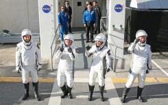 Crew-11 mission astronauts pause outside the Neil A. Armstrong Operations and Checkout Building en route to launch complex LC-39A at the Kennedy Space Center in Cape Canaveral, Florida on August 1, 2025