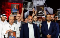 Wael Al-Dahdouh, Al Jazeera's Gaza bureau chief, stands with anchor and presenter Mohamed Krichen and presenter Tamer Almisshal during a moment of silence to honour five of their colleagues killed in an overnight Israeli strike in Gaza City
