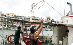 Fishermen secure their boat as Typhoon Podul approaches Taiwan on Wednesday