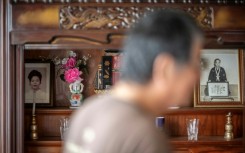 A portrait (L) of Takemasa Kinjo's mother, who was killed by a US Marine in 1974