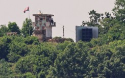 A North Korean soldier stands guard in a watch tower next to a giant loudspeaker near the Demilitarized Zone (DMZ) dividing the two Koreas in June