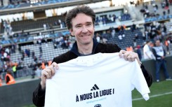Antoine Arnault, whose family owns Paris FC, holds a t-shirt marking the club's promotion to Ligue 1