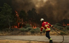 Firefighters try to extinguish a wildfire at Casal do Monte village in Trancoso, Portugal on August 13, 2025