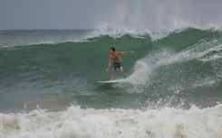 A surfer rides a wave at La Pared beach as Hurricane Erin approaches in Luquillo, Puerto Rico