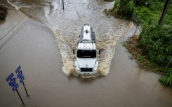 A truck drives through a road in Naguabo, Puerto Rico that was hit by flooding from Hurricane Erin