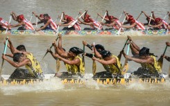 Participants paddle hard on their boat during the race held on the Kuantan River