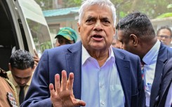 Sri Lanka's former president Ranil Wickremesinghe gestures as he arrives to appear before a court after his arrest