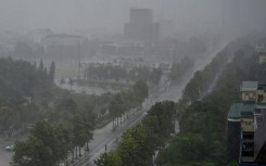Rain falls above the buildings and a street in Vinh city on August 25, 2025, before Typhoon Kajiki makes landfall in Vietnam