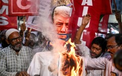 Activists burn an effigy of Trump to protest against tariff hikes during a demonstration in Kolkata