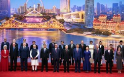 In this photograph distributed by the Russian state agency Sputnik, Russia's President Vladimir Putin, Chinese President Xi Jinping, his wife and foreign leaders pose during the Shanghai Cooperation Organization (SCO) Summit