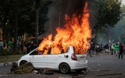 A car burns after being set ablaze during a protest against the Mobile Brigade Corps, or 'Brimob' in Jakarta