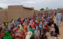 Sudanese residents gather to receive free meals in El-Fasher, a city besieged by Sudan's paramilitary Rapid Support Forces (RSF) for more than a year, in thr Darfur region