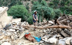 A man stahnds in the rubble of his quake -shattered home in Nurgal, Eastern Afghanistan, on September 4