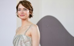 Emma Stone poses on the red carpet before the premiere of 'Bugonia'