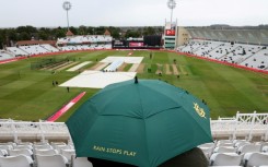 A spectators sits under an umbrella as rain washes out the third T20 between England and South Africa at Trent Bridge without a ball being bowled