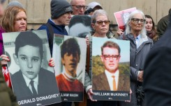 Relatives gathered outside the court bearing posters of those killed on Bloody Sunday