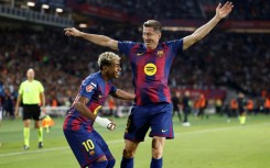 Barcelona's Polish forward Robert Lewandowski celebrates with Lamine Yamal after the winger set him up to score against Real Sociedad