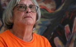 Roberta Hill, residential school survivor from the Mohwak Institute, poses next to a painting by Robert Gary Miller, also a survivor of the Mohawk Institute, during the site's unveiling as a museum in Brantford, Ontario on September 30, 2025