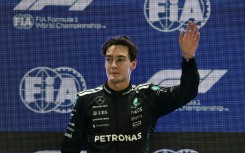 Mercedes' British driver George Russell waves as he celebrates getting pole position
