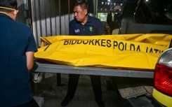 Police officials transfer the remains of a student, killed in the collapse at a boarding school on Indonesia's Java island