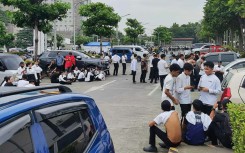 Employees at a shopping mall gather outside the building in Davao City, on the southern island of Mindanao after a 7.4-magnitude earthquake struck off the southern Philippines