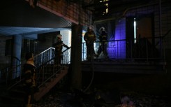 Ukrainian firefighters work in a residential building, damaged during the massive Russian drone and missile strikes