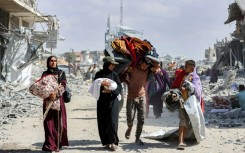People carried children and belongings as they made their way through the rubble of destroyed buildings to return home