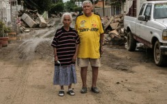 Hilario Reynosa and his wife Elodia Reyes, who survived the flooding in the Morelos neighborhood after being trapped by the overflowing Cazones River, pose for a portrait on a street covered by debris in Poza Rica, Mexico