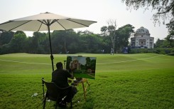 An artist paints a Mughal-era heritage monument at Delhi Golf club during the DP World India Championship