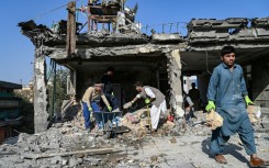 Workers remove debris from a house damaged after a a suspected air strike in Kabul