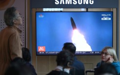 People at a train station in Seoul watch footage of a North Korean missile test