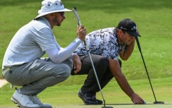 Patrick Reed (right) and fellow American John Catlin line up putts during the first round of the International Series Philippines on Thursday