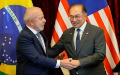 Brazil's President Luiz Inacio Lula da Silva (L) and Malaysia's Prime Minister Anwar Ibrahim shake hands after holding a press conference