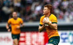 Australia's Tane Edmed runs with the ball against Japan