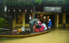 People are evacuated from a hotel by boat in flood waters following heavy rains in Hoi An
