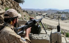A Taliban security personnel stands guard along a road near the Ghulam Khan zero-point border crossing between Afghanistan and Pakistan